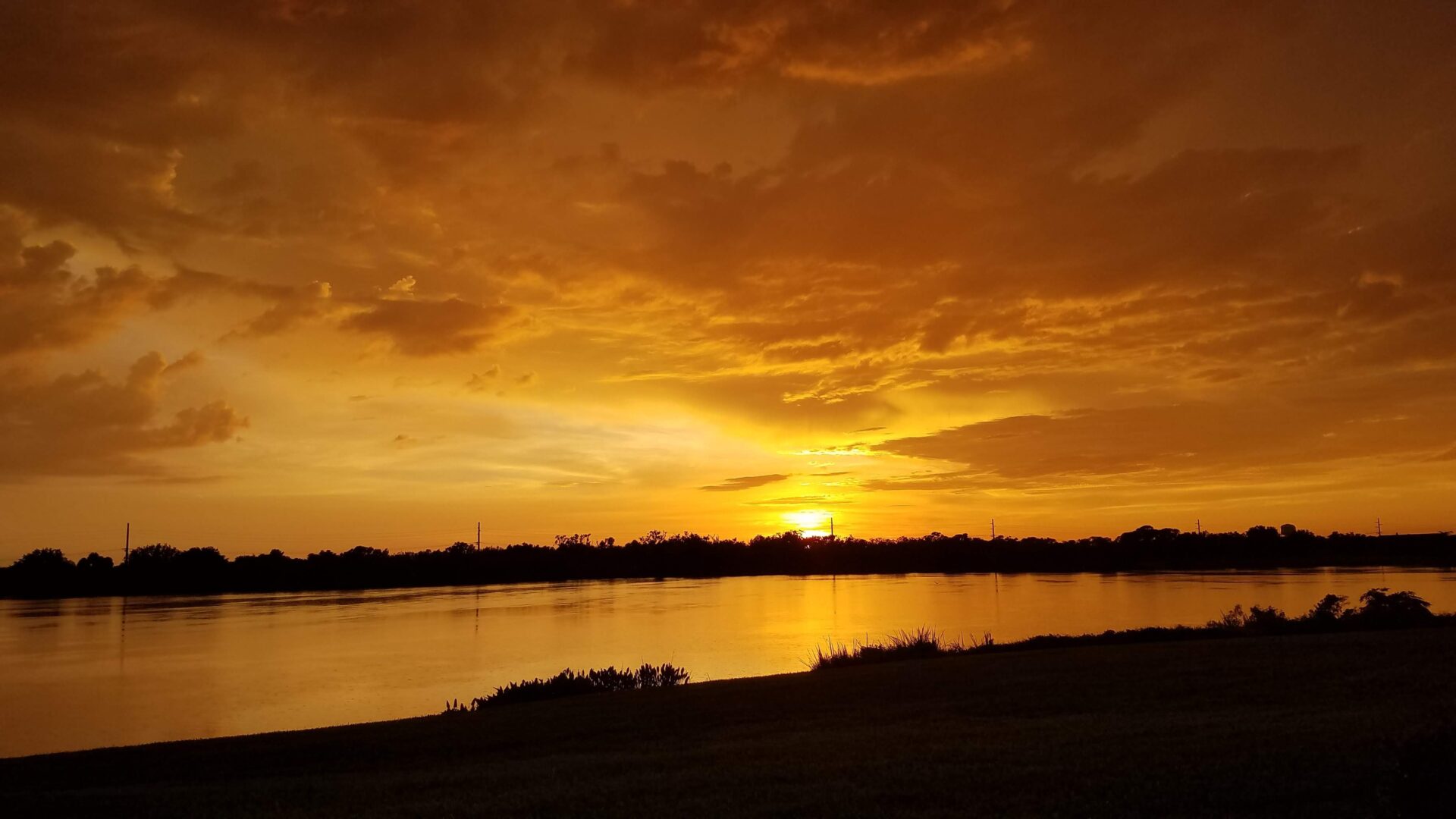 A sunset over the water with some people on it