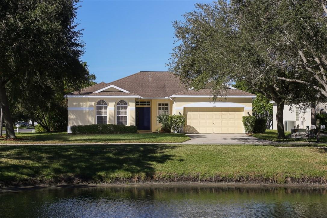 A house with a driveway and trees in the background